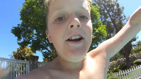 Boy Jumps Into Swimming Pool and Swims Underwater Stock Footage 129780945