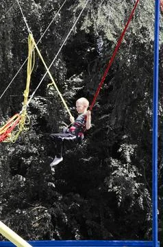 Boy jumps on a swing in the park Stock Photos