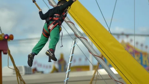 Boy Jumps On Trampoline With Rope Support Vídeo Stock 88135800
