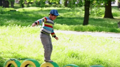 The boy jumps on the wheels in the park Stock Footage 76426617