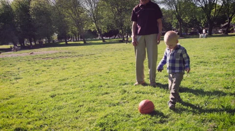 Boy kicking ball in park Stock Footage 64452157