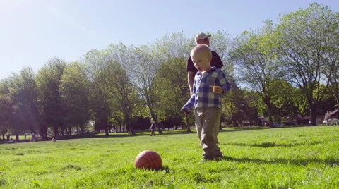 Boy kicking ball in park Stock Footage 64452164