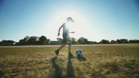 Boy kicks the ball. The kid is training to dribble the ball on a large football Stock-Footage 154094570