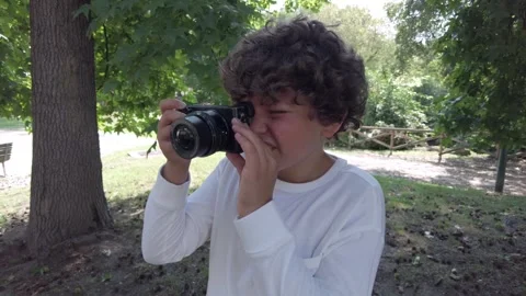 Boy kid 9 years old taking pictures photos with camera in a park during the holi Vídeo Stock 246297426