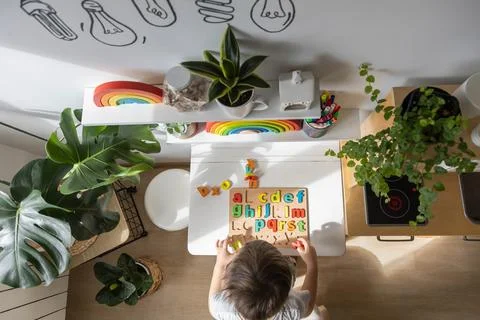 Boy kid assembling flat letters wooden puzzle block cell playing childish Stock Photos