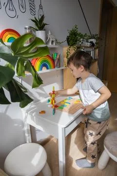 Boy kid assembling flat letters wooden puzzle block cell playing childish Stock Photos