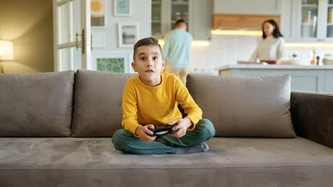 Boy kid playing video computer game at home living room Stock Photos