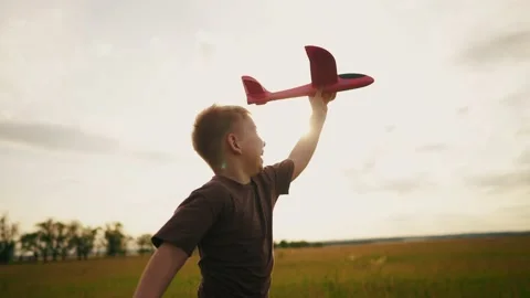 Boy kid run in the park across the field play with an toy airplane in his hand a Vídeo Stock 200818249