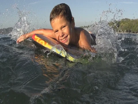 Boy / kid surfing - jumping waves Body Board / 4k Stock Footage 76877160
