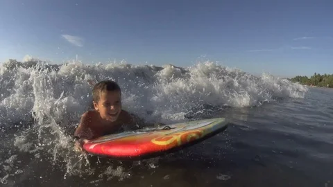 Boy / kid surfing - jumping waves Body Board 4k Stock Footage 77029013