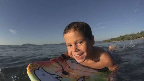 Boy / kid surfing - jumping waves Body Board 4k Stock Footage 77031449