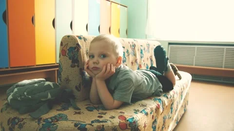A boy in a kindergarten dangles his legs Stock Footage 153052957