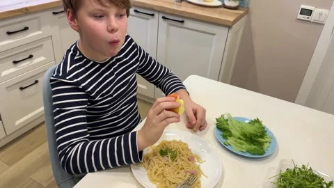 The boy is in the kitchen, holding a slice of pizza Stock Footage 302933182