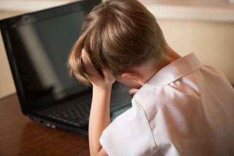Boy with laptop at table Stock Photos