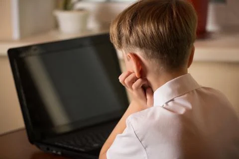 Boy with laptop at table Stock Photos
