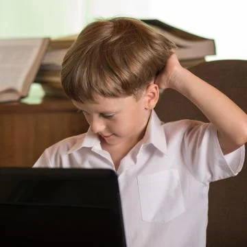 Boy with laptop at table Stock Photos