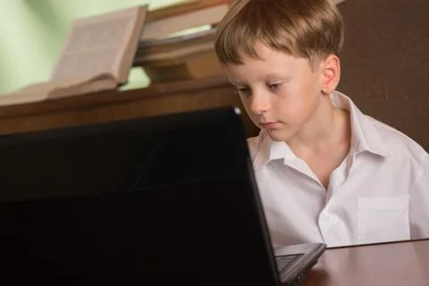 Boy with laptop at table Stock Photos