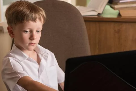 Boy with laptop at table Foto stock
