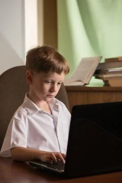 Boy with laptop at table Foto stock
