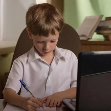 Boy with laptop at table Stock Photos