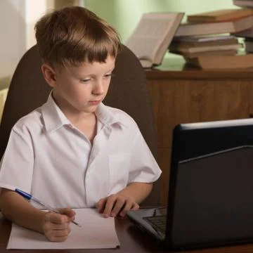 Boy with laptop at table Stock Photos