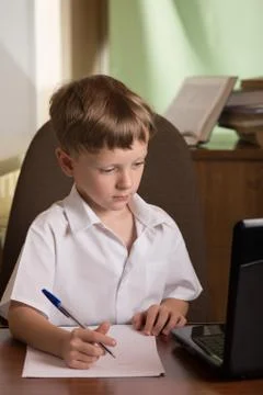 Boy with laptop at table Foto stock