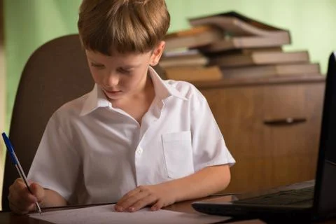 Boy with laptop at table Stock-Fotos