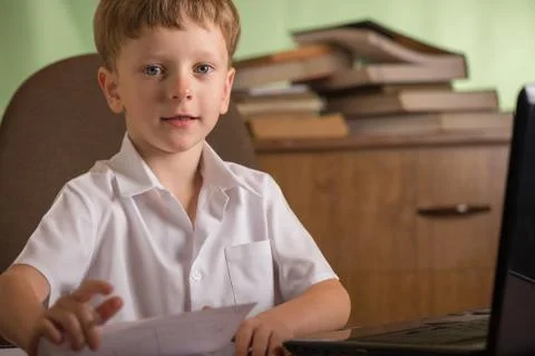 Boy with laptop at table Stock Photos