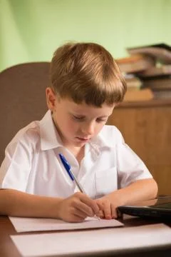 Boy with laptop at table Stock Photos