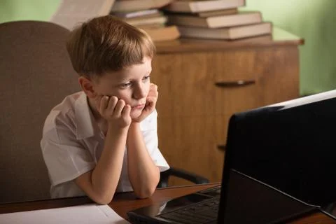 Boy with laptop at table Stock Photos