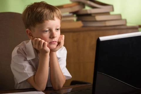 Boy with laptop at table Stock Photos