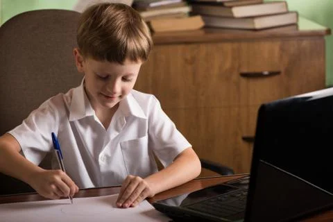Boy with laptop at table Stock Photos