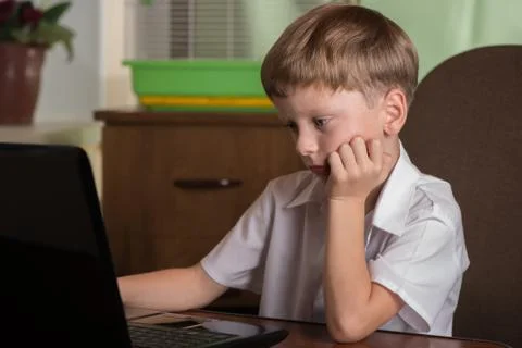 Boy with laptop at table Stock Photos