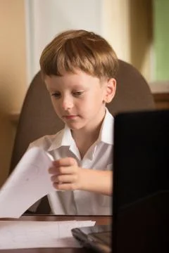 Boy with laptop at table Stock Photos