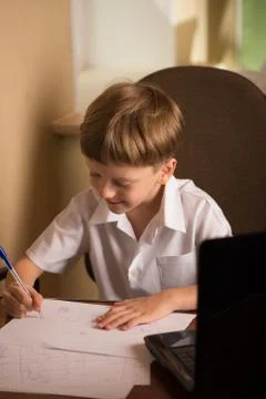 Boy with laptop at table Stock Photos