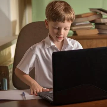 Boy with laptop at table Stock Photos
