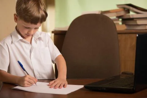 Boy with laptop at table Stock Photos