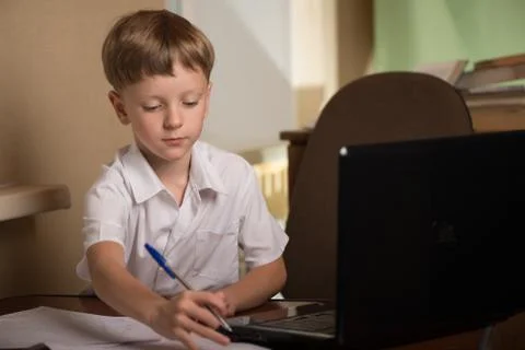 Boy with laptop at table Foto stock