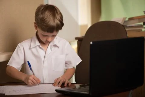 Boy with laptop at table Stock Photos