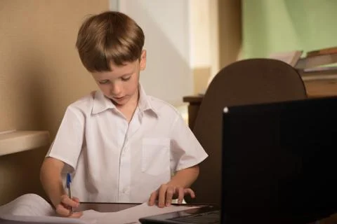 Boy with laptop at table Stock Photos