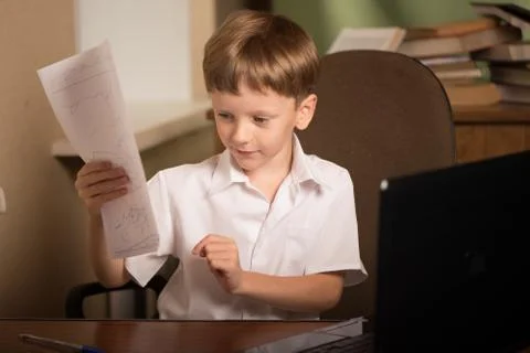 Boy with laptop at table Stock Photos