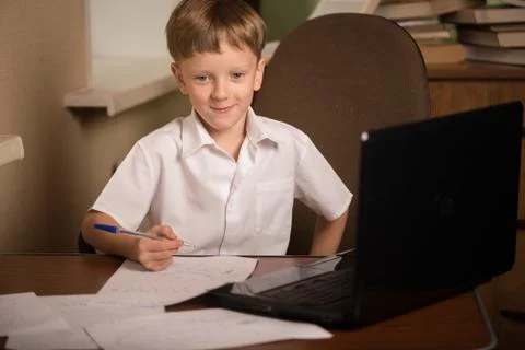 Boy with laptop at table Foto stock