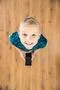 The boy laugh to camera and hold a phone in hands. View from above Photo