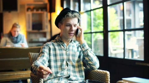 Boy laughing while chatting on cellphone in the cafe Stock-Footage 62410839