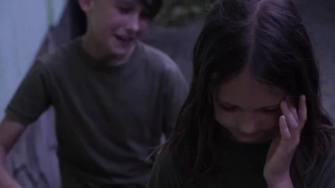 The boy laughs, humiliates and points to a lonely sad girl standing aside Stock Footage 246173023