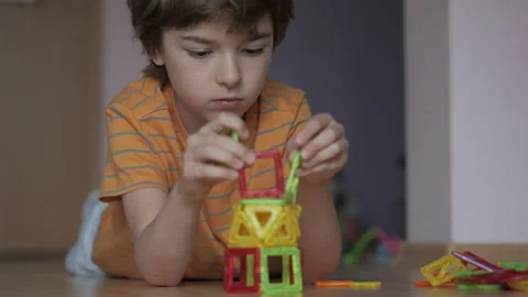 Boy is Laying on Floor Playing With Set of Magnetic Building Blocks.. Boy P.. Видео 283532995