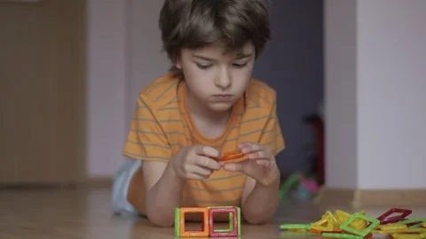 Boy is Laying on Floor Playing With Set of Magnetic Building Blocks.. Boy P.. Stock-Footage 327597319