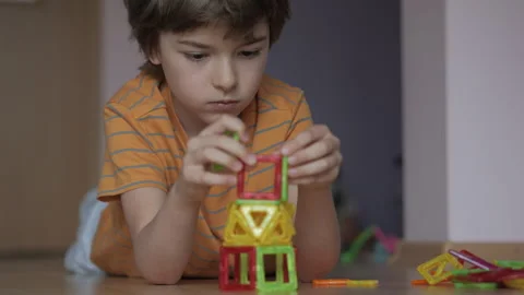Boy is Laying on Floor Playing With Set of Magnetic Building Blocks.. Boy P.. Stock-Footage 327599026