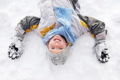 Boy Laying On Ground Making Snow Angel Stock Photos