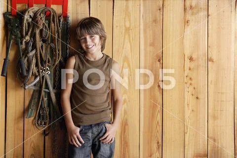Boy leaning against stable wall Stock Photos